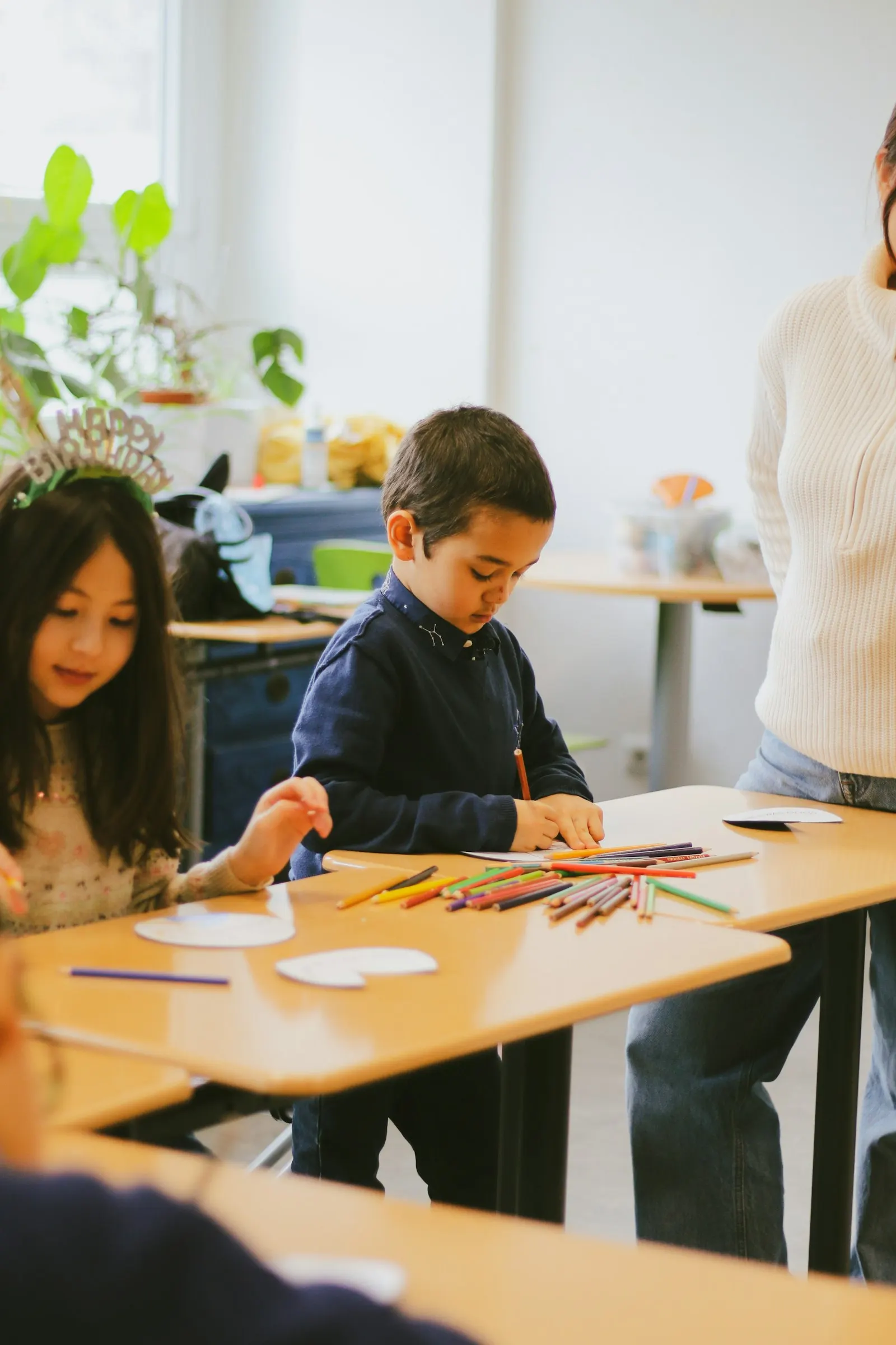 Des enfants assis à une table font des activités manuelles