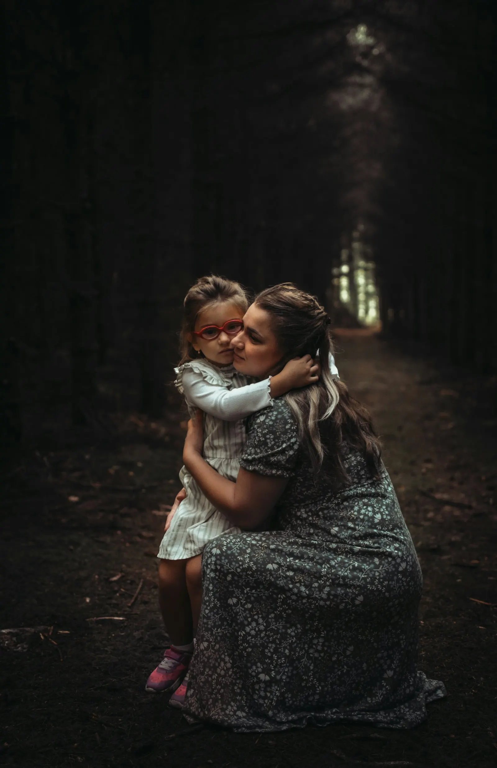 Une femme tient un enfant dans ses bras dans une forêt