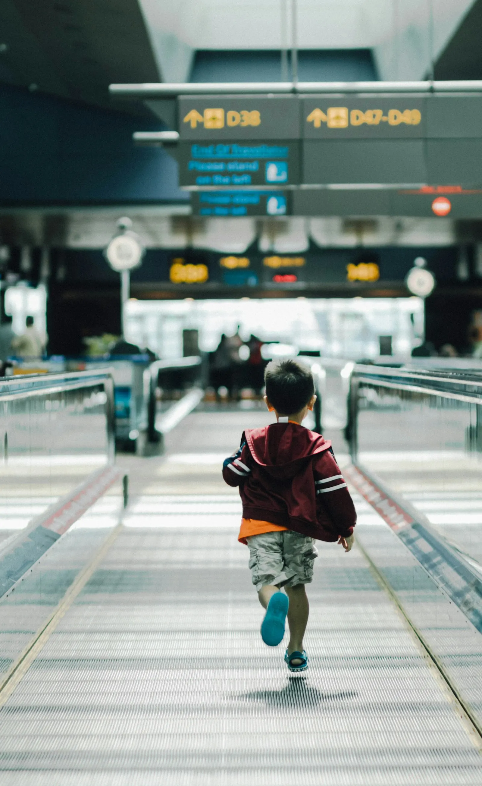 Un garçon court dans un hall d'aéroport