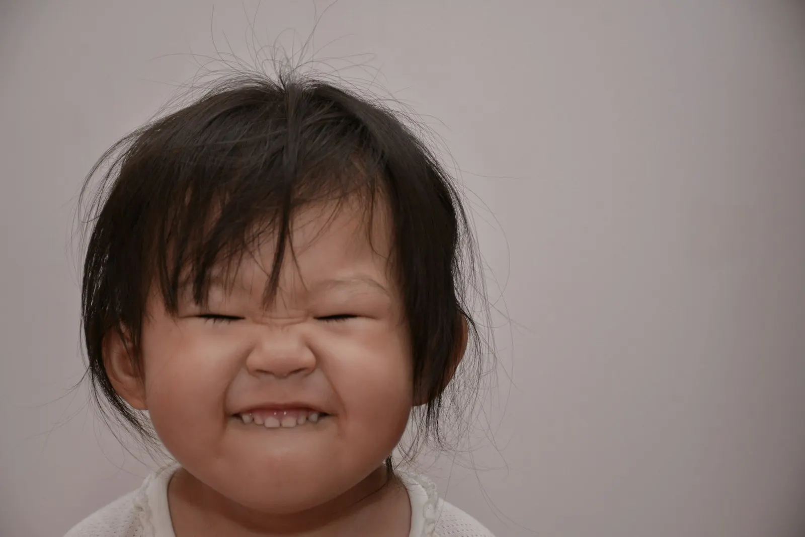 Une petite fille plisse les yeux en serrant les dents